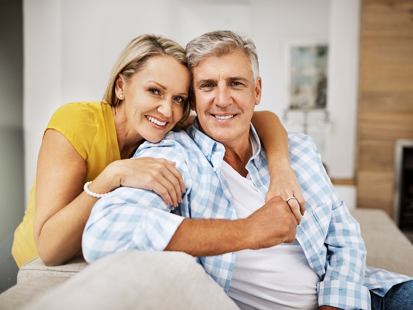 Middle age couple smiling on couch