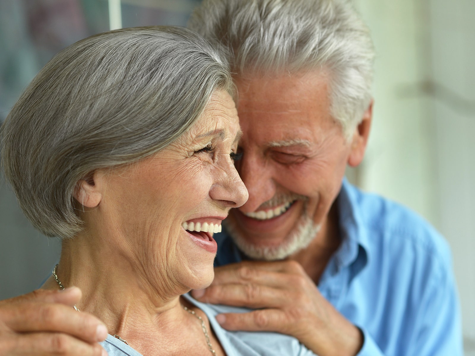Elderly couple smiling and laughing looking at each other